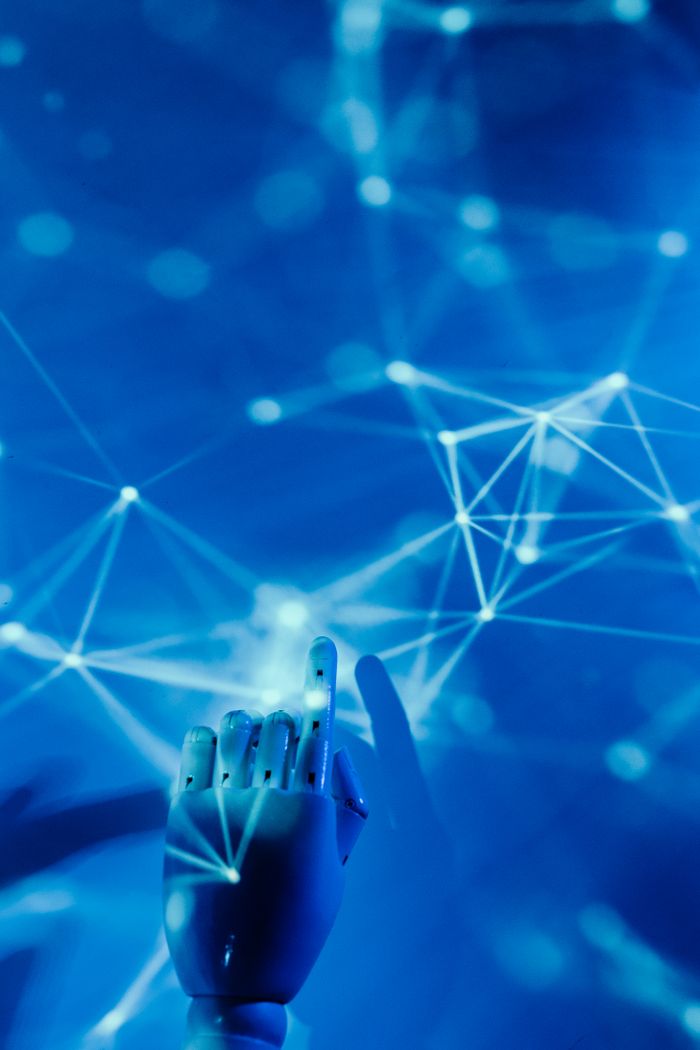 home-hero Futuristic robotic hand touching a digital network on a blue background.